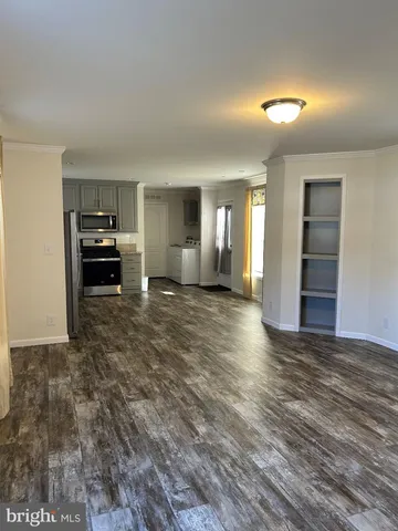 a view of a livingroom with wooden floor and kitchen space with a sink