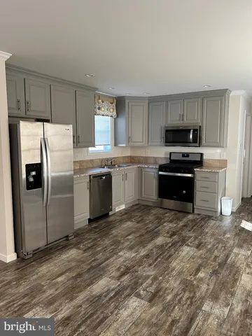 a kitchen with stainless steel appliances granite countertop a sink a stove a refrigerator and a microwave