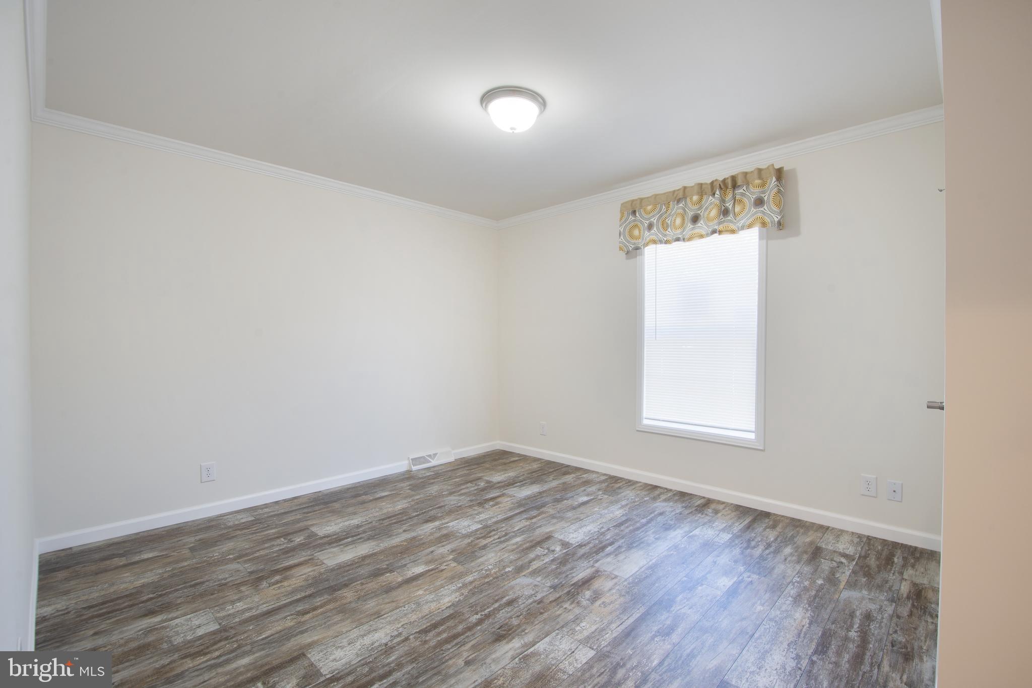 54 Sherwood Forest Way, Unit 54 Hartly, DE 19953 - Photo 10 of 12 an empty room with wooden floor and windows