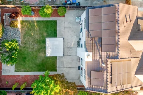 an aerial view of residential houses with outdoor space and swimming pool