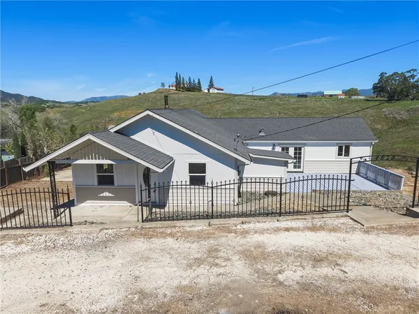 a view of a house with a small yard and wooden fence