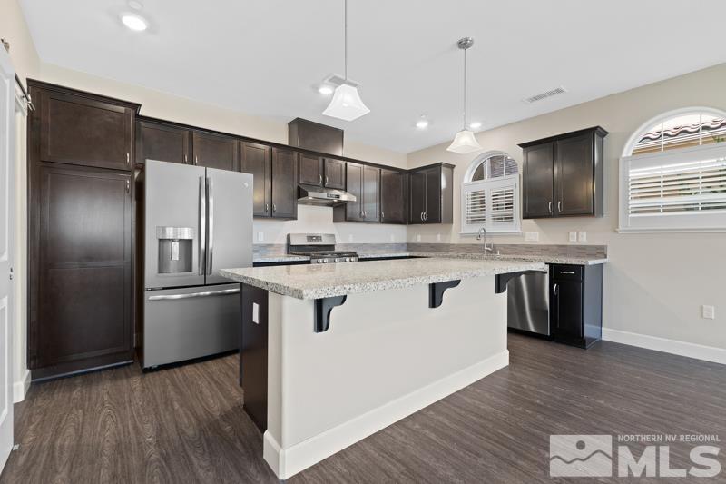 1900 Dark Horse Road, Unit B Reno, NV 89521 - Photo 2 of 34 a kitchen with kitchen island granite countertop stainless steel appliances a refrigerator cabinets and wooden floor