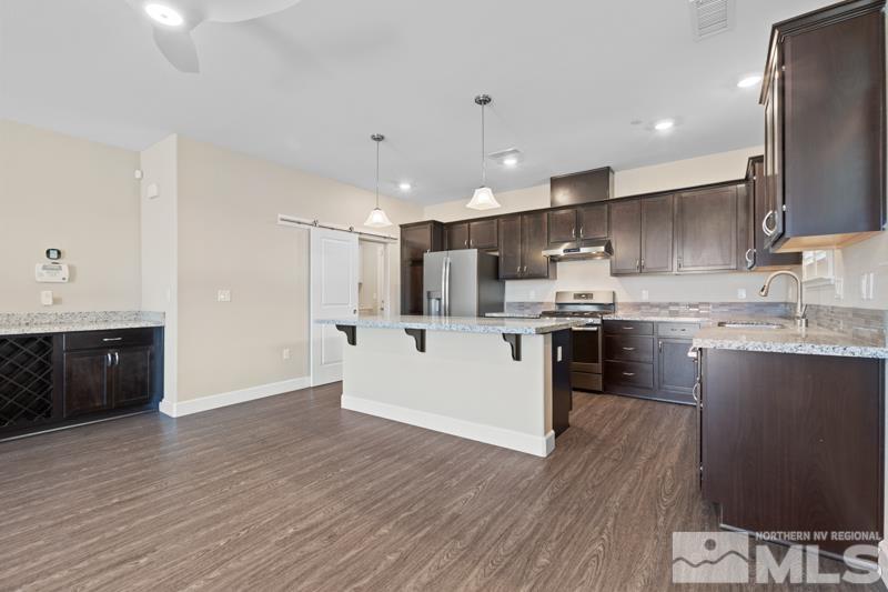 1900 Dark Horse Road, Unit B Reno, NV 89521 - Photo 8 of 34 a kitchen with kitchen island granite countertop wooden floors stainless steel appliances and sink