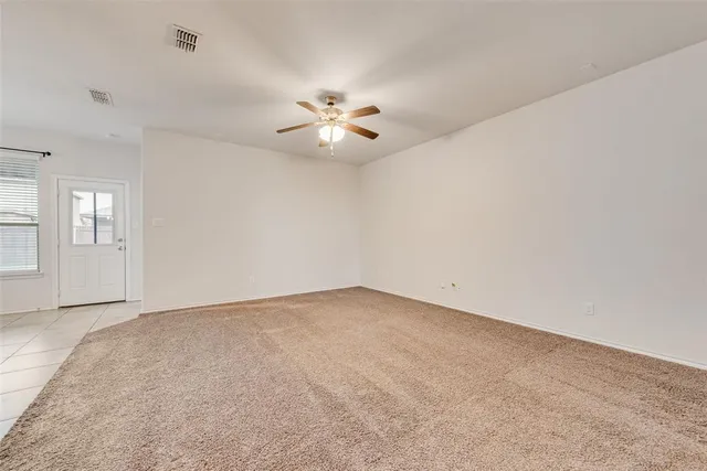 a view of an empty room with a chandelier fan