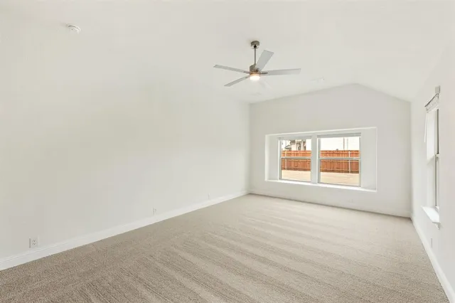 an empty room with a window and a ceiling fan