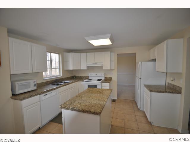 a kitchen with a sink refrigerator and cabinets