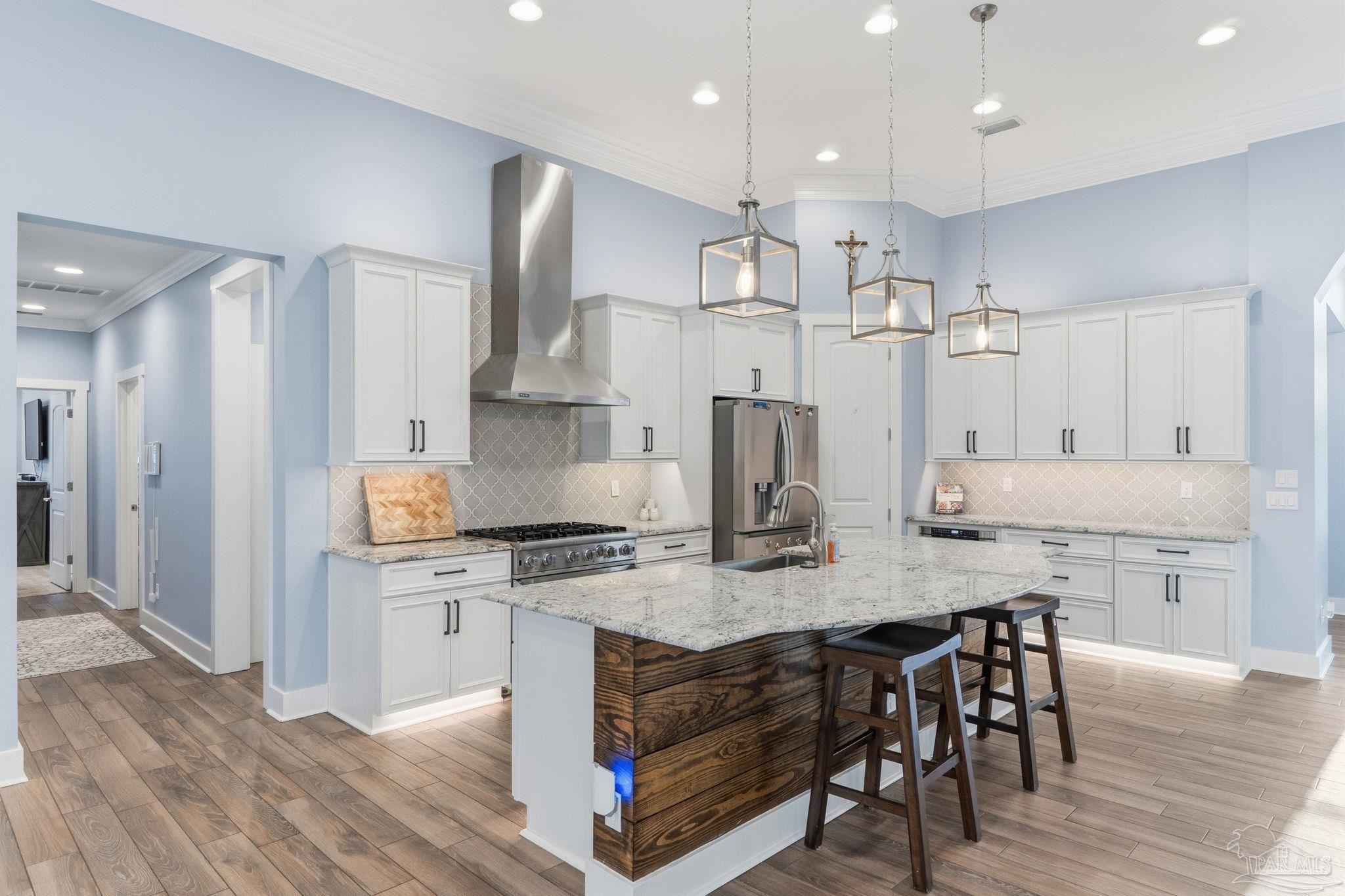 2018 Rambling Oaks Drive Cantonment, FL 32533 - Photo 24 of 64 a kitchen with kitchen island granite countertop a kitchen island hardwood floor sink stove and refrigerator