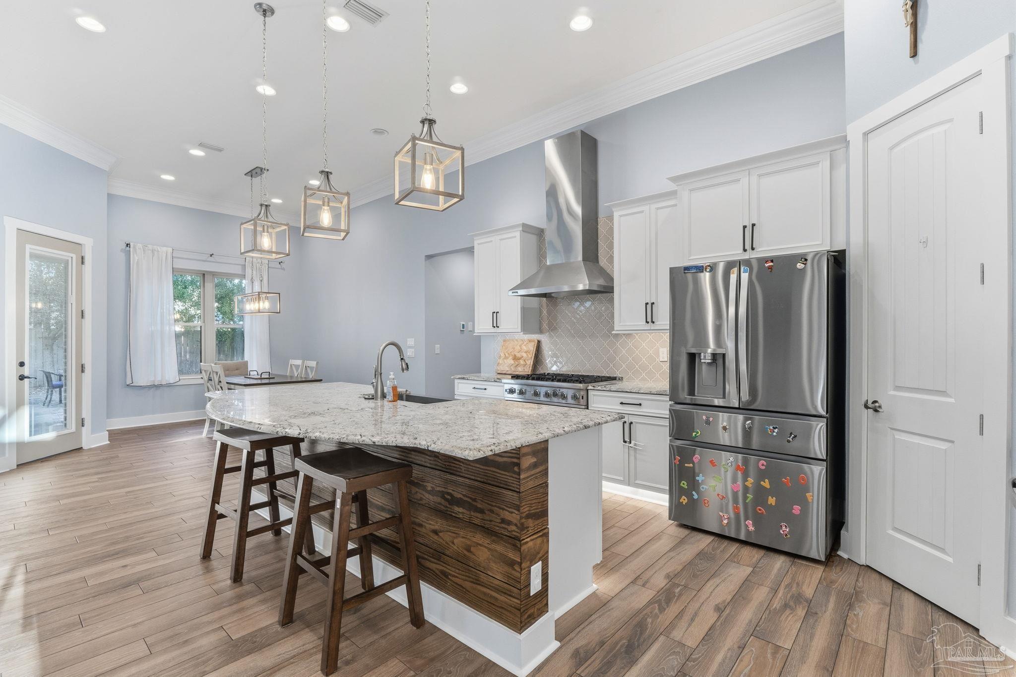 2018 Rambling Oaks Drive Cantonment, FL 32533 - Photo 26 of 64 a kitchen with stainless steel appliances granite countertop a refrigerator a sink dishwasher a stove and a refrigerator with wooden floor