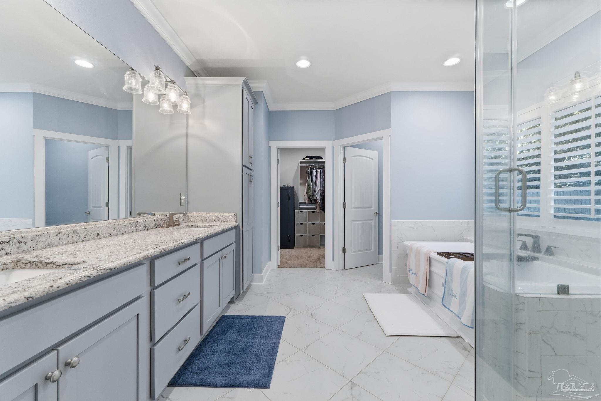 2018 Rambling Oaks Drive Cantonment, FL 32533 - Photo 33 of 64 a bathroom with a granite countertop sink a large mirror and a shower