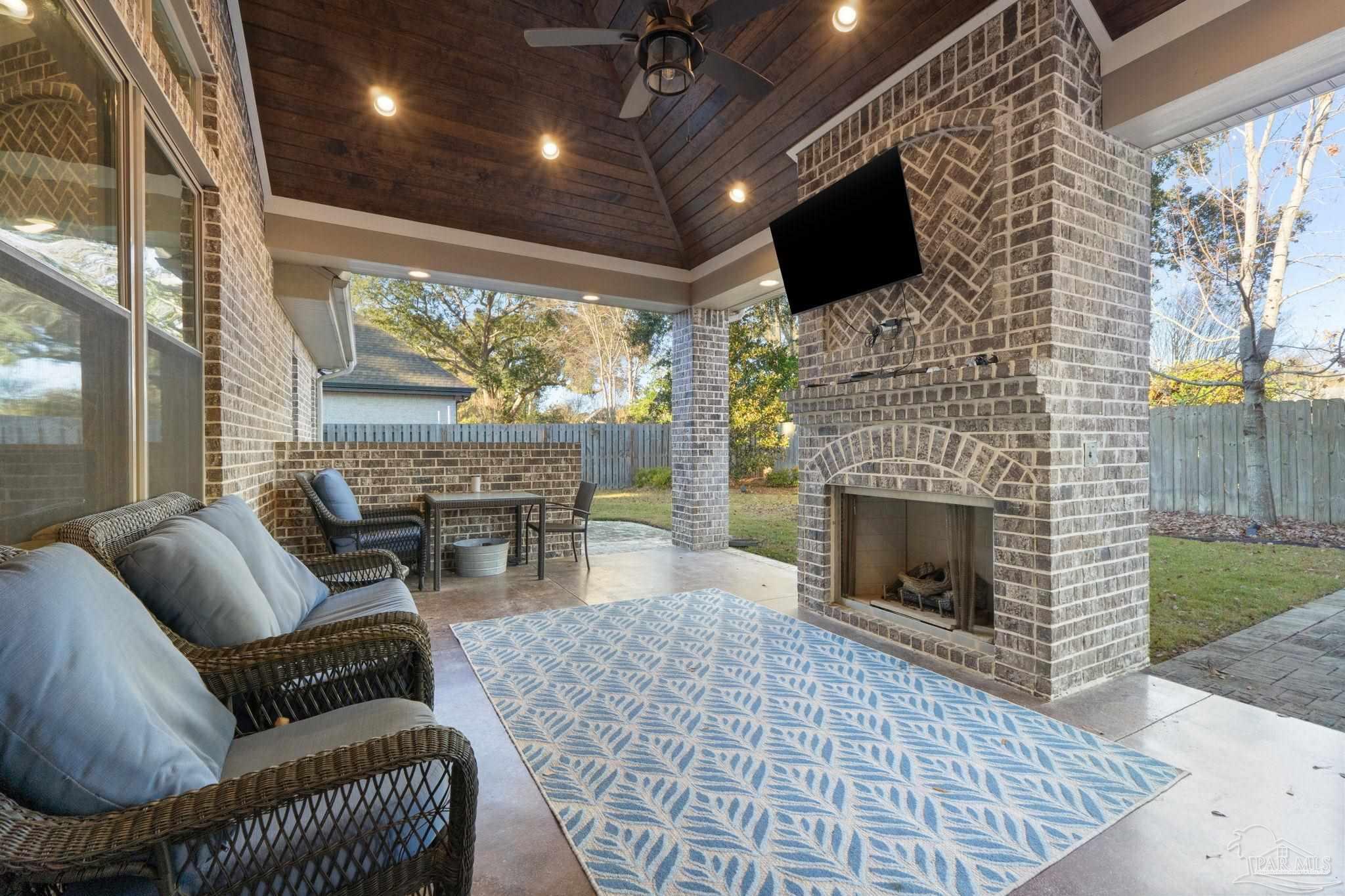 2018 Rambling Oaks Drive Cantonment, FL 32533 - Photo 48 of 64 a living room with furniture a flat screen tv and a fireplace