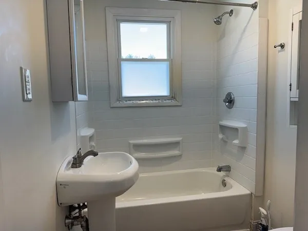 a bathroom with a sink a window and shower