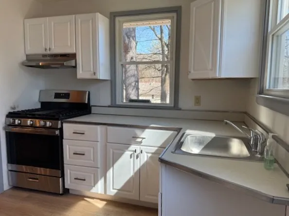 a kitchen with a sink cabinets and window