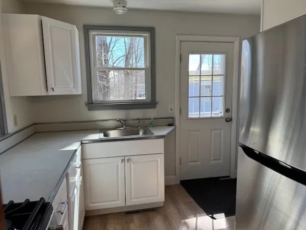 a kitchen with a sink a window and cabinets