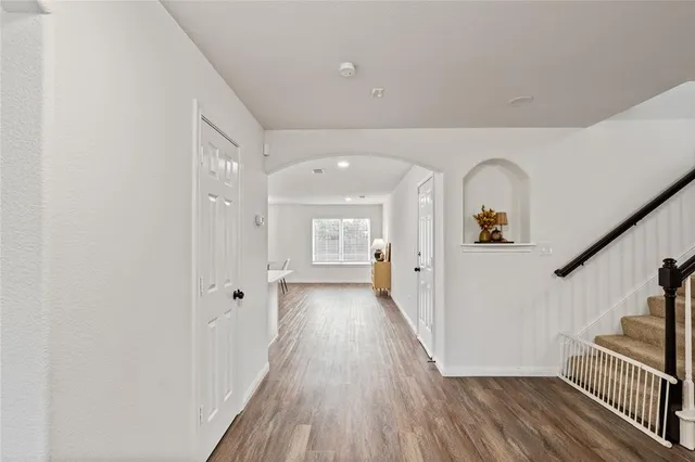 a view of a hallway with wooden floor and staircase