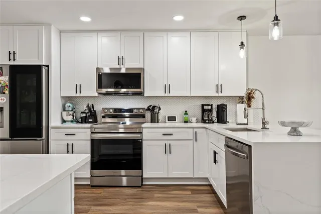 a kitchen with stainless steel appliances granite countertop a stove a sink and a refrigerator