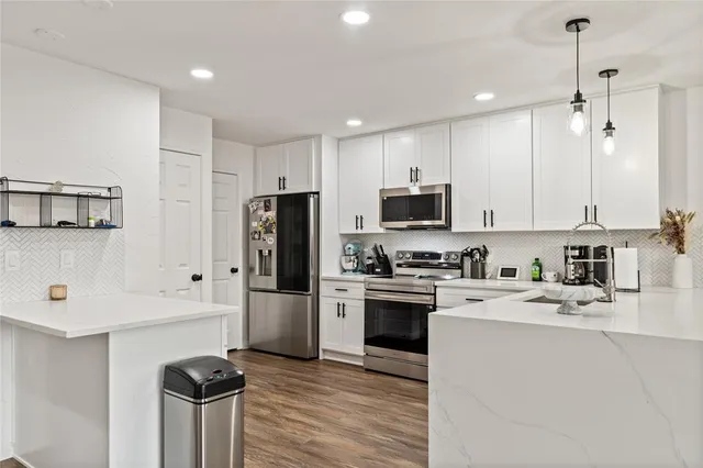 a kitchen with stainless steel appliances granite countertop a refrigerator stove microwave and sink