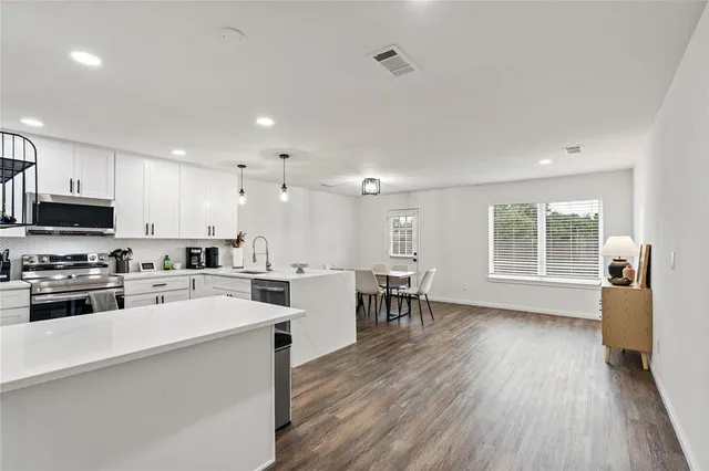 a kitchen with a sink a microwave and wooden floor
