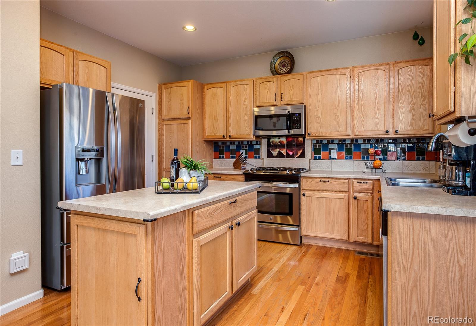 10839 Brooklawn Road Highlands Ranch, CO 80130 - Photo 11 of 32 a kitchen with stainless steel appliances a sink window and cabinets