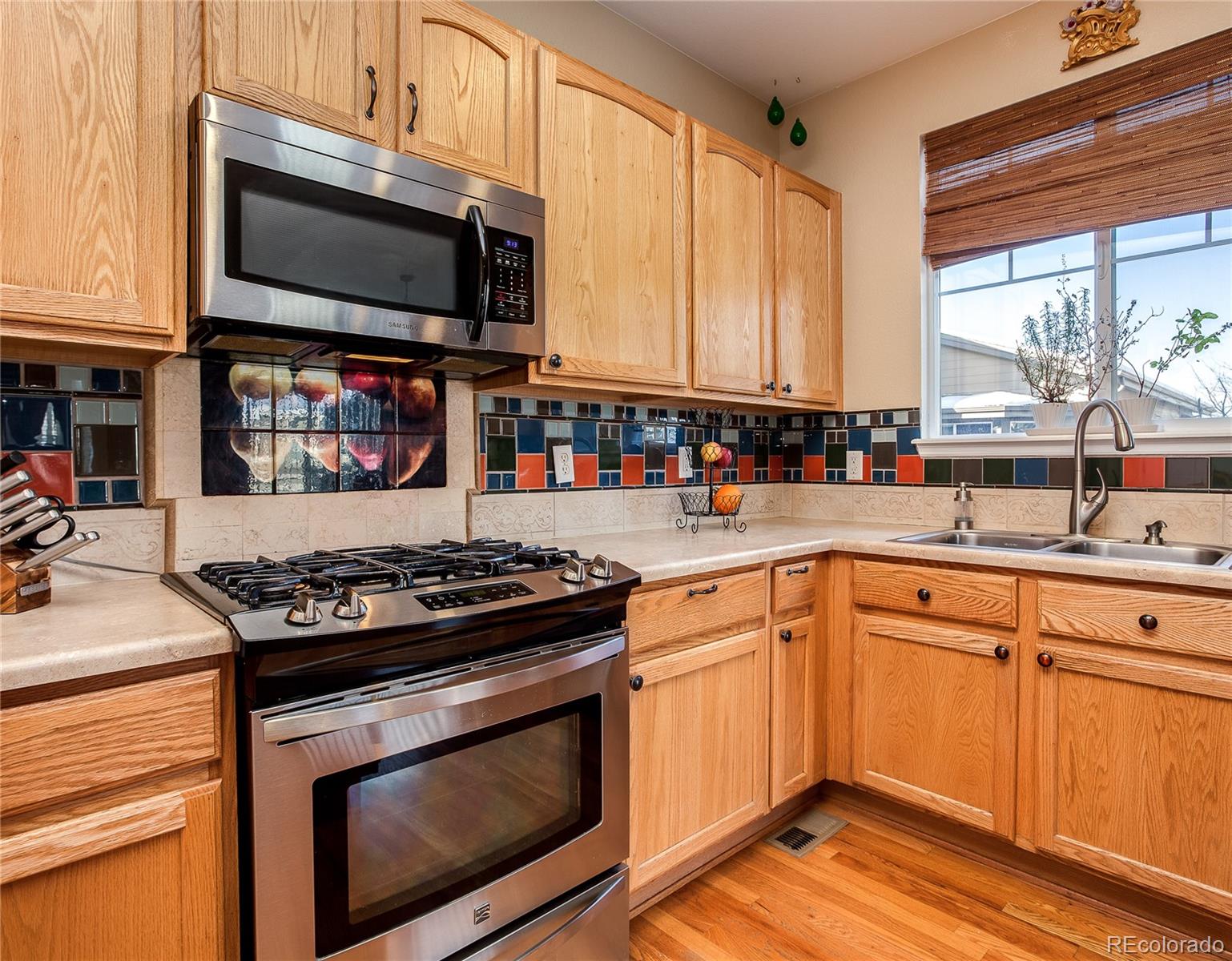 10839 Brooklawn Road Highlands Ranch, CO 80130 - Photo 13 of 32 a kitchen with stainless steel appliances a stove a sink and a microwave