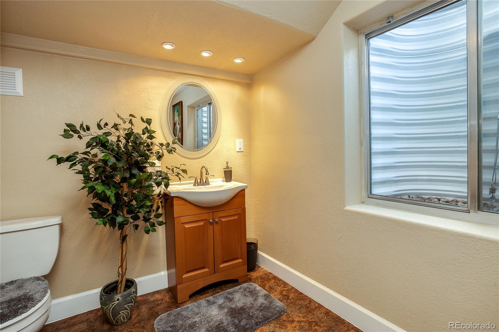 10839 Brooklawn Road Highlands Ranch, CO 80130 - Photo 18 of 32 a view of bathroom with a toilet a sink and a mirror