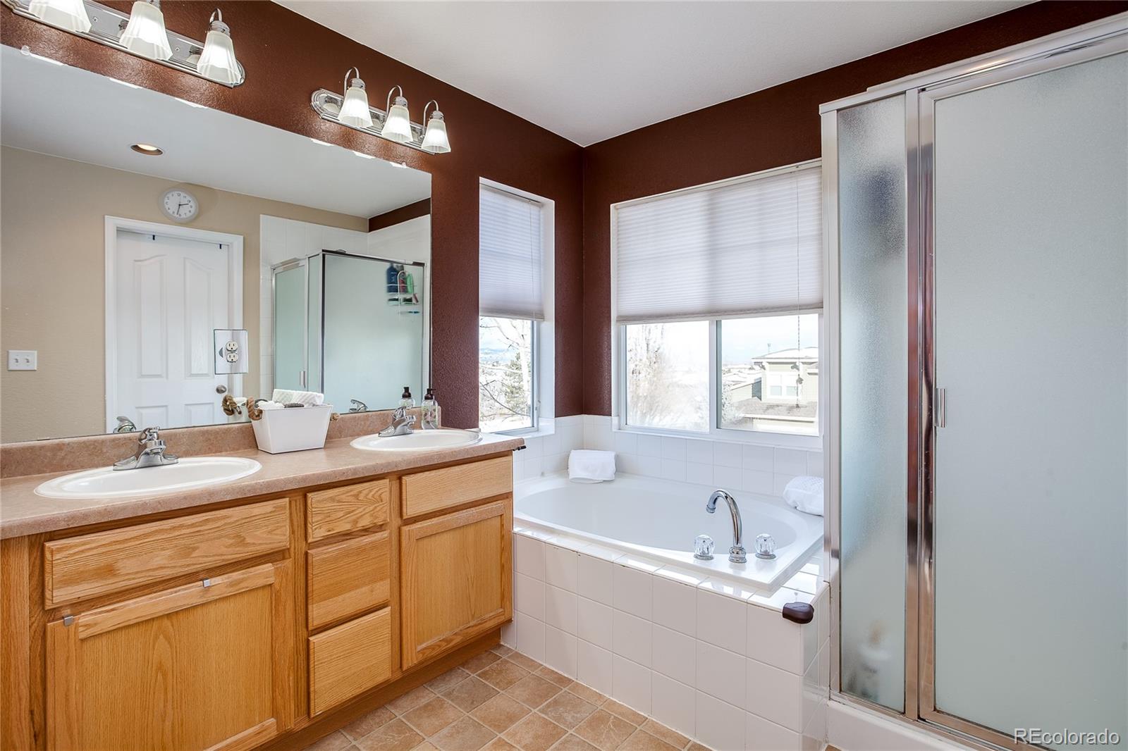 10839 Brooklawn Road Highlands Ranch, CO 80130 - Photo 21 of 32 a bathroom with a tub sink and mirror