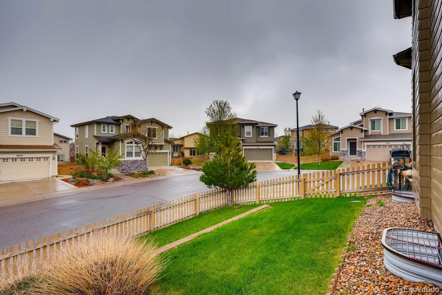 10839 Brooklawn Road Highlands Ranch, CO 80130 - Photo 31 of 32 a view of a house with a yard and a fence