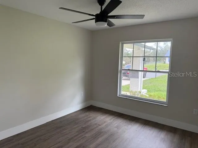 a view of an empty room with wooden floor