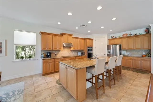 a kitchen with stainless steel appliances kitchen island granite countertop a table and chairs in it