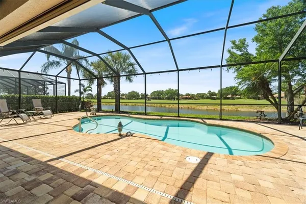 a view of a swimming pool with a bench in the patio