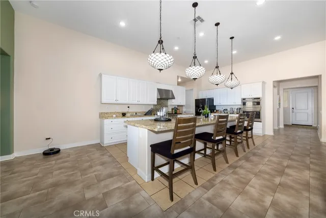 a large kitchen with stainless steel appliances kitchen island granite countertop a stove a sink a dining table and chairs