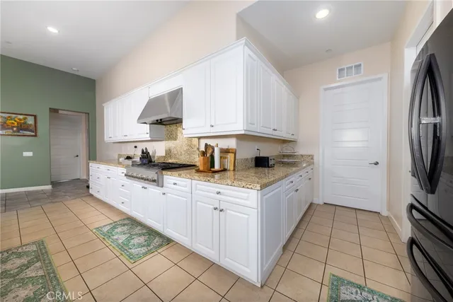a large kitchen with kitchen island a stove a sink dishwasher and a fireplace with wooden floor