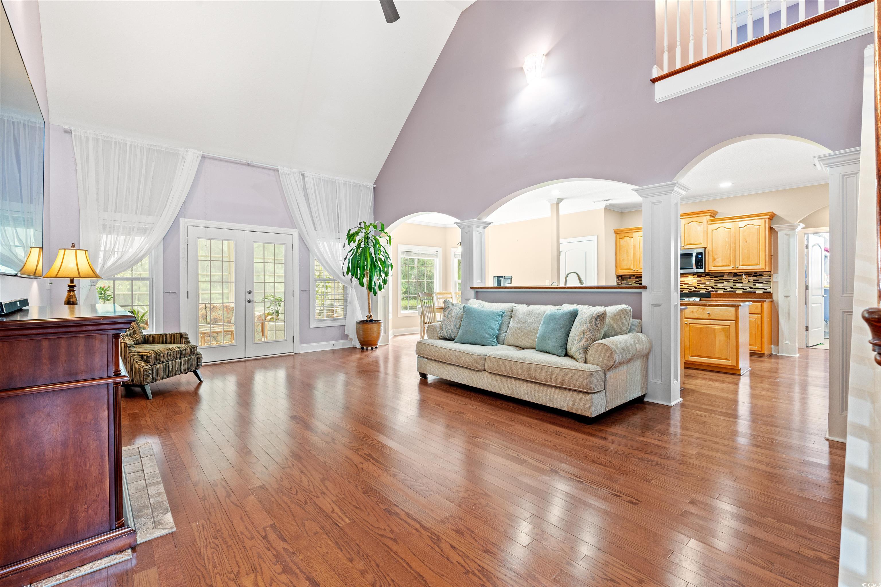 109 Eden Court Murrells Inlet, SC 29576 - Photo 4 of 31 Living area with ornate columns, french doors, arched walkways, light wood-style floors, and a high ceiling