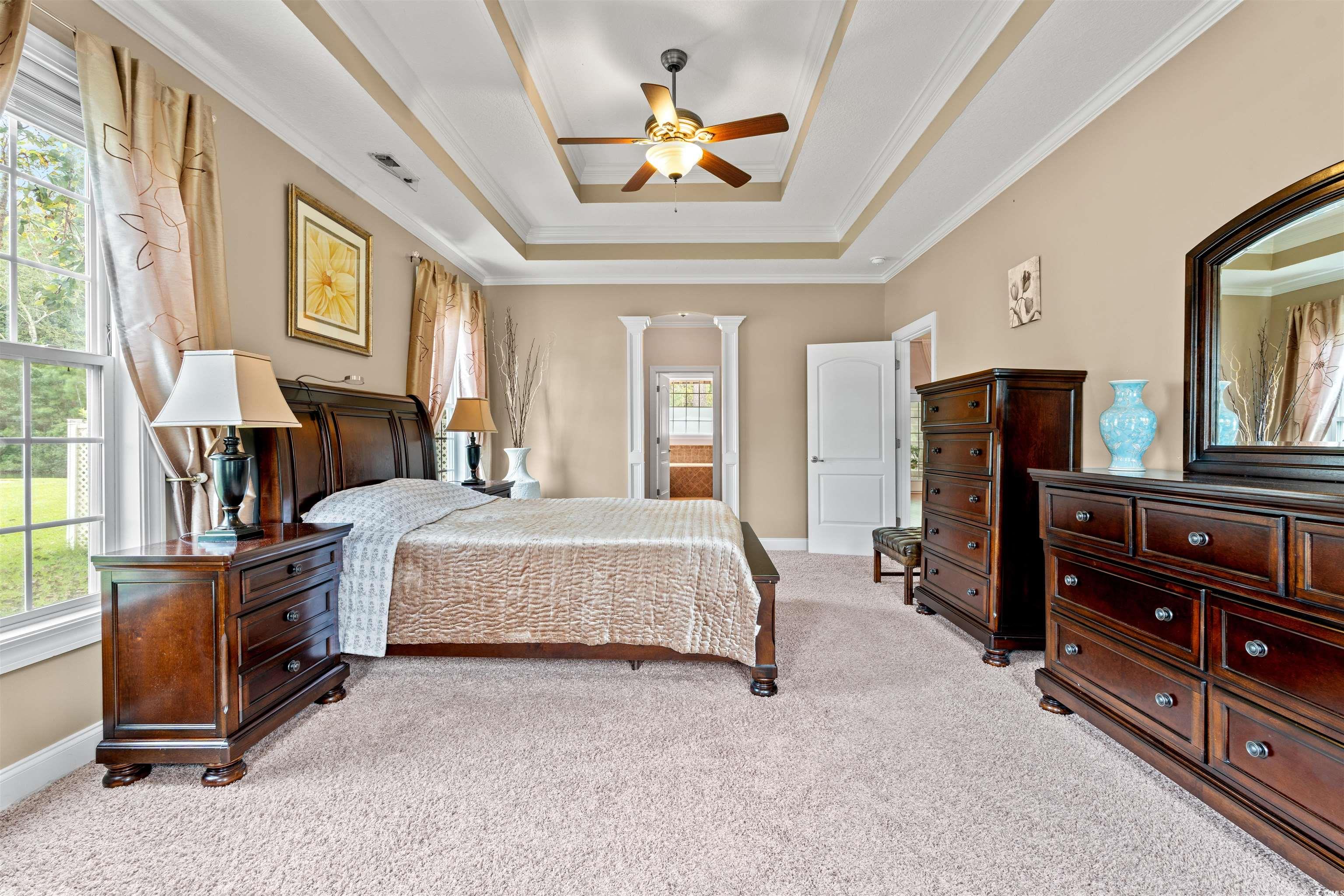 109 Eden Court Murrells Inlet, SC 29576 - Photo 9 of 31 Bedroom with light carpet, a raised ceiling, ornamental molding, ceiling fan, and ensuite bath