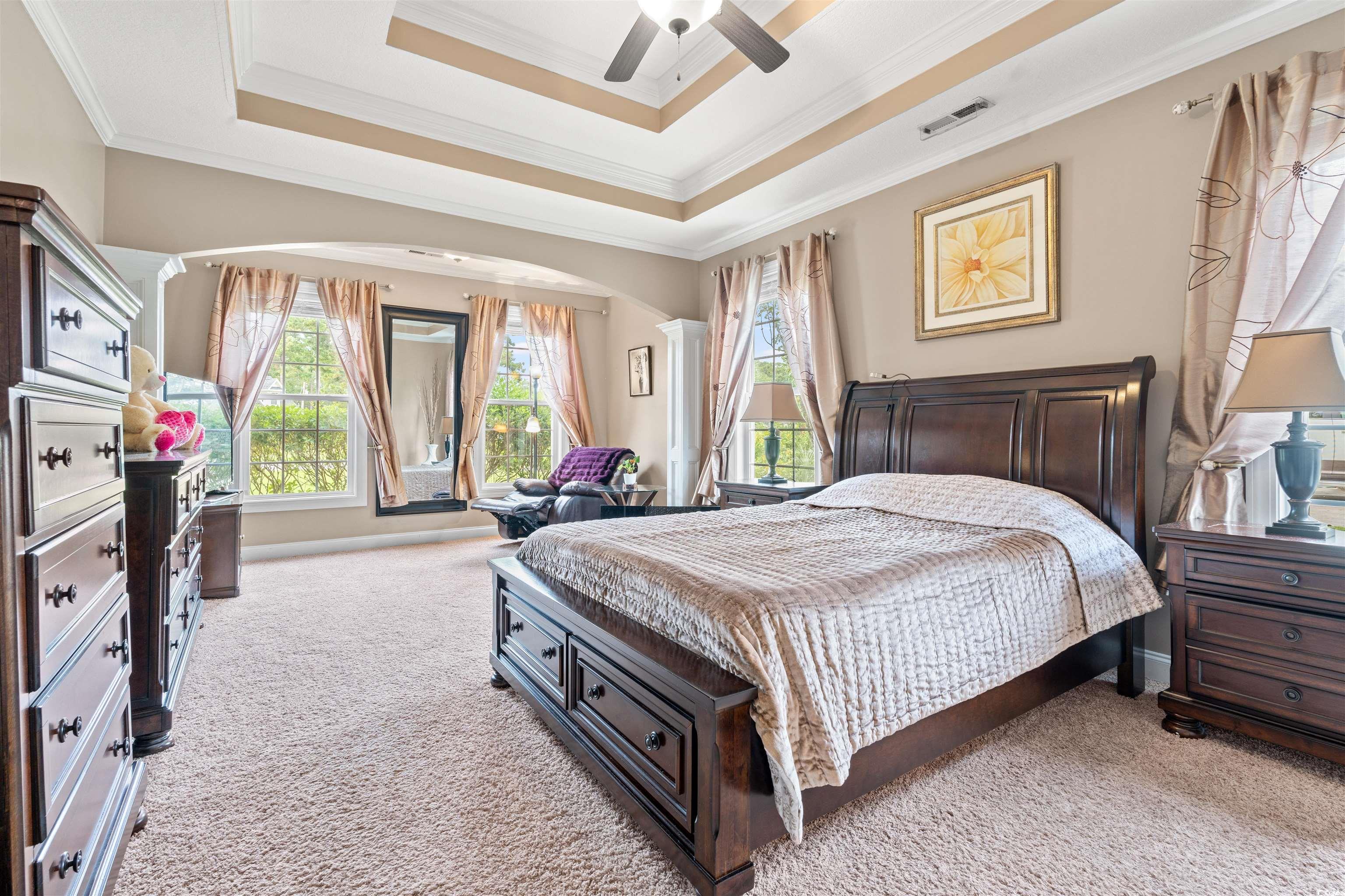 109 Eden Court Murrells Inlet, SC 29576 - Photo 10 of 31 Bedroom with a raised ceiling, light carpet, crown molding, arched walkways, and ceiling fan