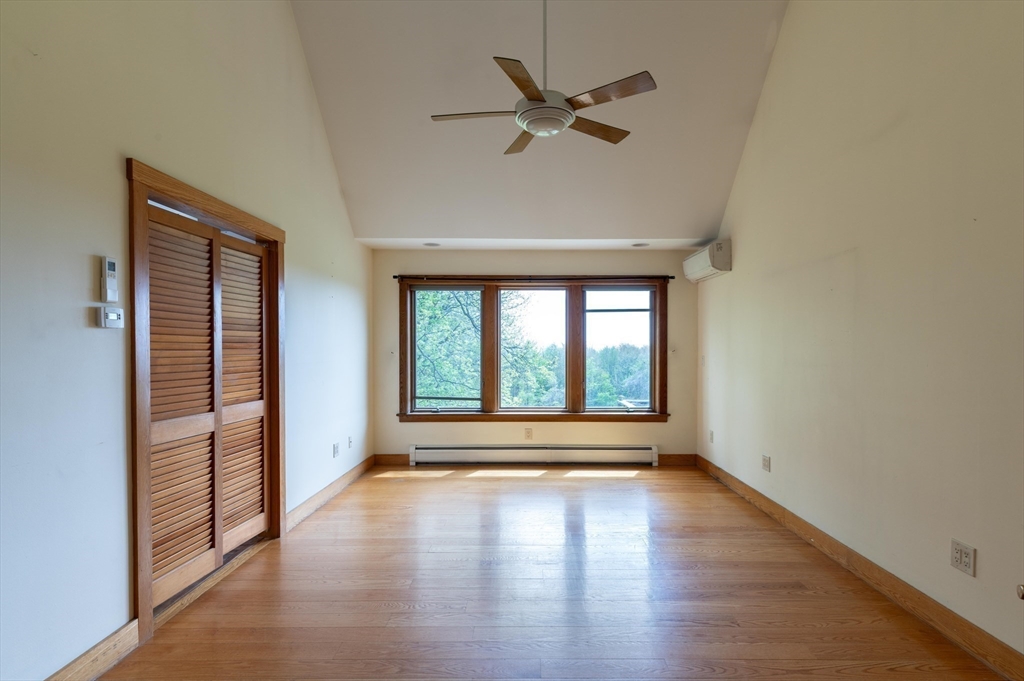 184 W Road Bernardston, MA 01337 - Photo 23 of 41 an empty room with wooden floor fan and windows