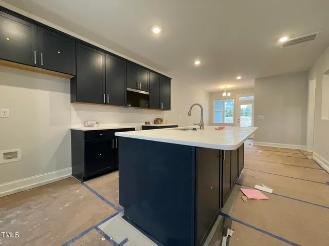 a kitchen with kitchen island a sink stainless steel appliances and cabinets