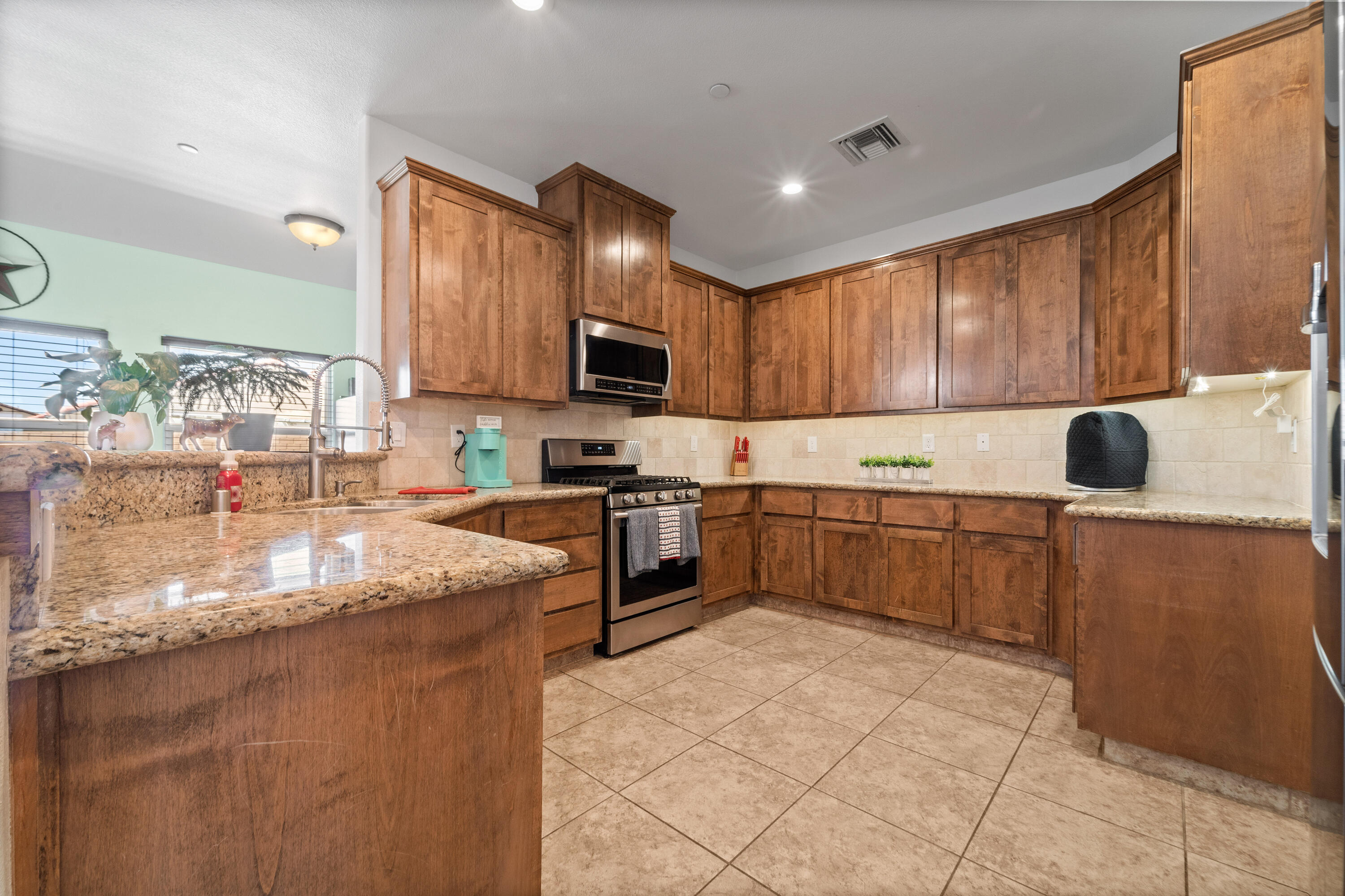 1231 Carolyn Street Ridgecrest, CA 93555 - Photo 17 of 49 a kitchen with stainless steel appliances granite countertop a stove sink and cabinets