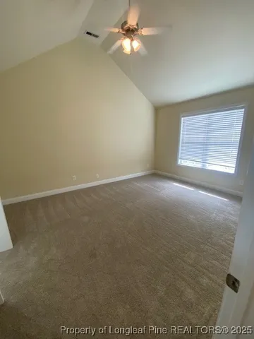 an empty room with a window and a ceiling fan