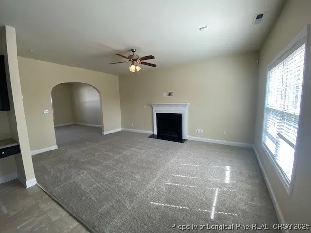an empty room with windows and fireplace