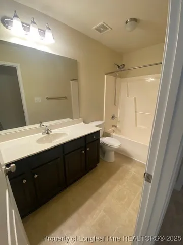 a bathroom with a double vanity sink a toilet and a mirror