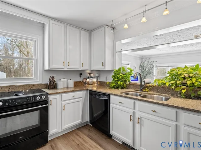 a kitchen with stainless steel appliances white cabinets and a stove top oven