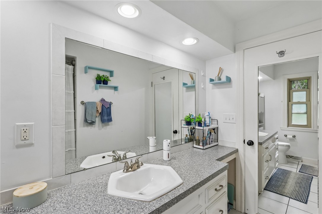 8310 Broadview Road Broadview Heights, OH 44147 - Photo 17 of 32 Built-in vanity with an integrated sink, dual recessed lighting, and a full-width mirror