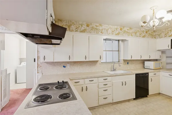 a kitchen with cabinets appliances a sink and a counter top space