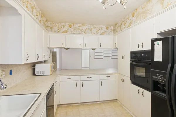 a kitchen with cabinets and wooden floor