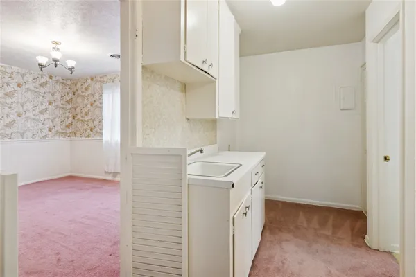 a utility room with cabinets washer and dryer