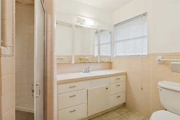 a bathroom with a granite countertop sink toilet a large mirror a vanity and shower