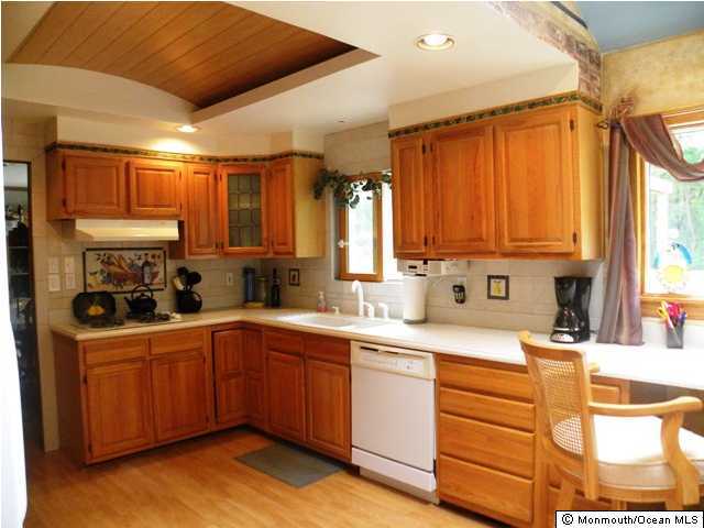 24 Pepperridge Road Howell, NJ 07731 - Photo 2 of 3 a kitchen with a sink a stove cabinets and wooden floor