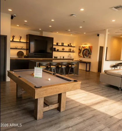 a view of a room with kitchen island stainless steel appliances wooden floor and windows