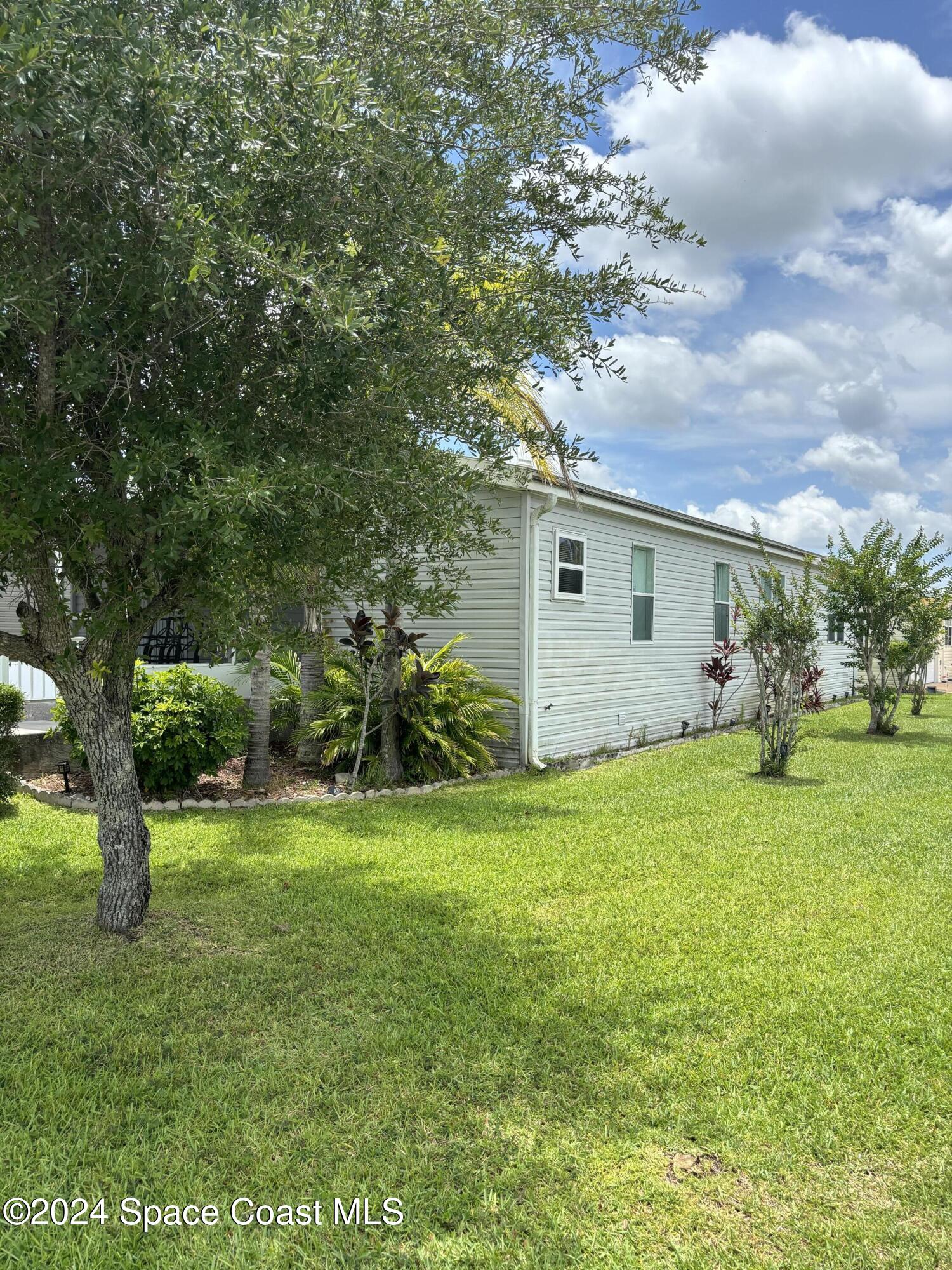 276 Timber Run Way Cocoa, FL 32926 - Photo 12 of 18 a backyard of a house with plants and large tree