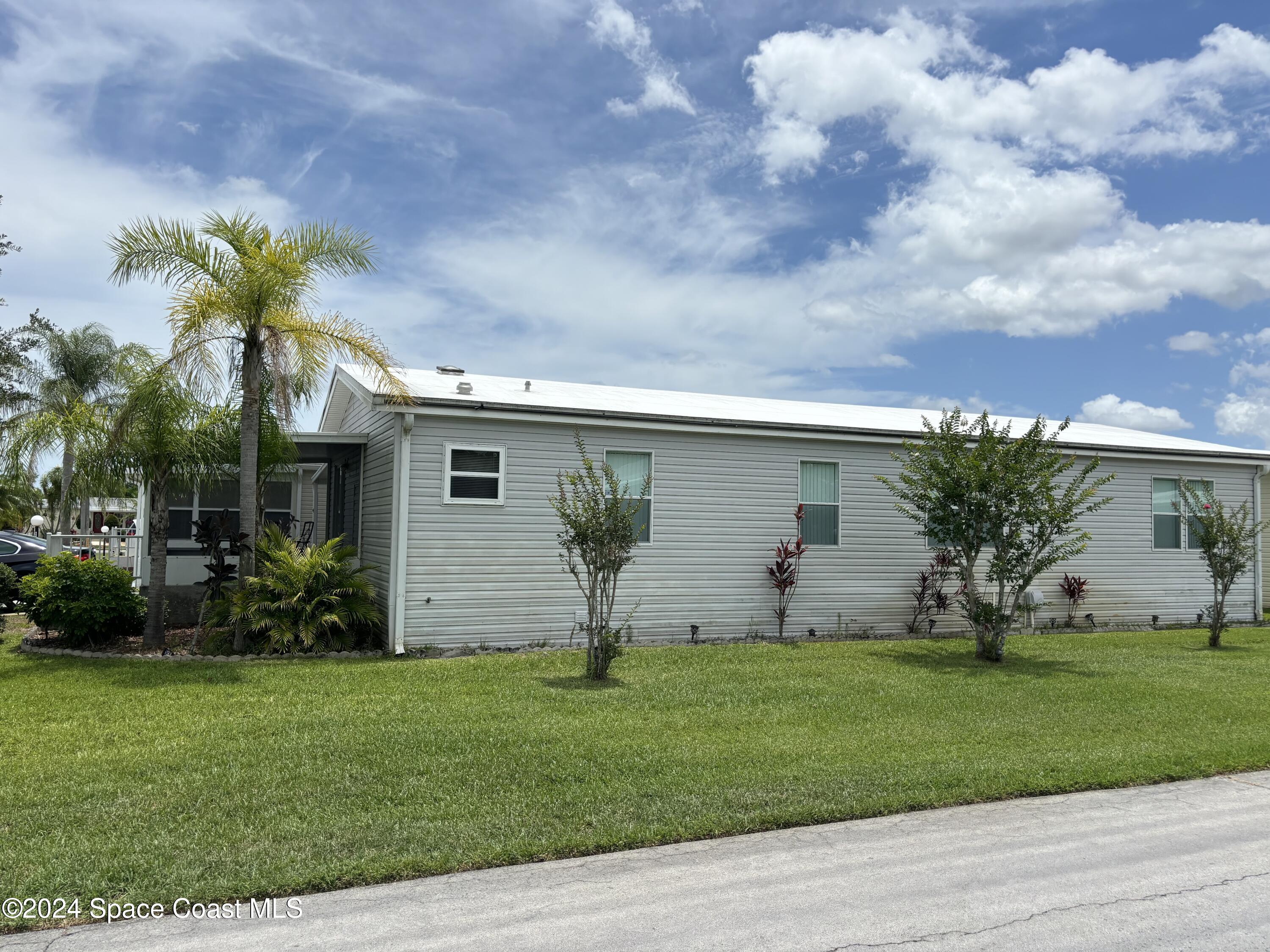 276 Timber Run Way Cocoa, FL 32926 - Photo 14 of 18 a view of a backyard with potted plants and a large tree